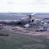 Ein Mi-24 Hind Hubschrauber der Bundeswehr fliegt über ein ländliches Gebiet.
