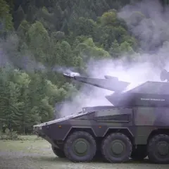 Ein moderner Radpanzer, der Nachfolger des Geparden, feuert in einer nebligen Waldkulisse.