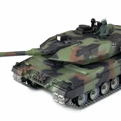 Ein detailgetreues Modell des Leopard 2A6M Panzers in Tarnfarben, mit einem sitzenden Soldaten in der Luke.