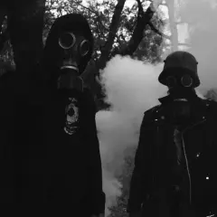 Zwei Personen in Gasmasken, umgeben von Rauch. Der Mann rechts trägt einen Stahlhelm, wie ihn der **Minenwerfer** im Ersten Weltkrieg trug.