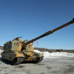 Eine russische Panzerhaubitze mit langer Kanone steht auf einem verschneiten Feld unter blauem Himmel.