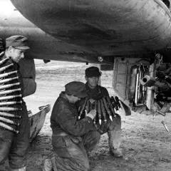 Soldaten laden Munition für ein Flugzeug. Ein Mann trägt Patronengurte, die mk 103 sind bereit.