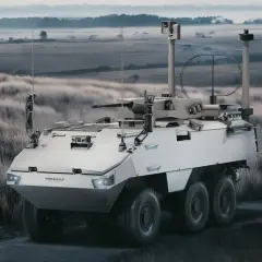 Ein gepanzertes Fahrzeug mit Bewaffnung steht in einer nebligen Landschaft. Die Frage, wo werden in Deutschland Panzer gebaut, bleibt offen.