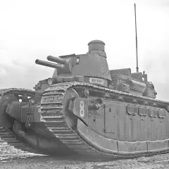 Ein schwerer Panzer, Modell char 2c, mit zwei Kanonen und dem Namen "Berry" auf dem Turm, steht auf schlammigem Gelände.
