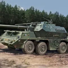 Eine Dana Howitzer, ein schweres Artilleriegeschütz, fährt durch einen Wald.