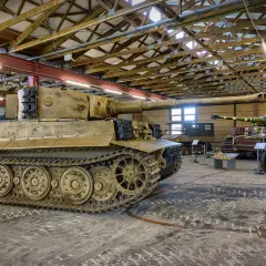 Im **Museum Panzer** stehen mehrere historische Fahrzeuge, darunter ein Tiger-Panzer und ein Halbkettenfahrzeug.