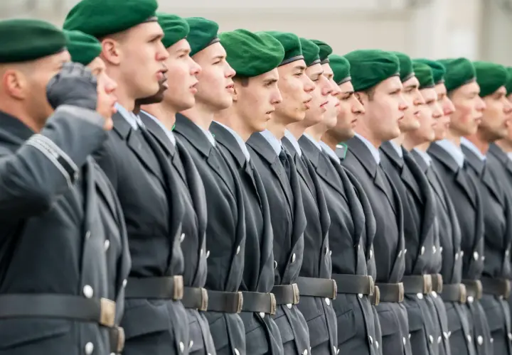 Soldaten der Bundeswehr in grünen Baretts und grauen Uniformen stehen stramm. Sie repräsentieren den niedrigsten Rang, bereit für ihren Dienst.