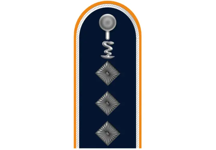 Dunkelblaues Kragenabzeichen mit silbernem Stab und Schlange, drei Rauten. Ein Feldwebel der Bundeswehr trägt dieses Abzeichen.