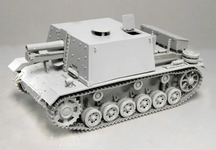 Graues Modell eines Geschützpanzers, das an die sig 33 erinnert, mit detaillierten Ketten und einer großen Kanone.