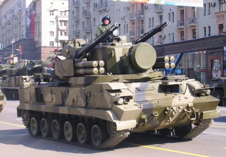 Ein 2K22 Tunguska Flugabwehrpanzer fährt in einer Parade. Der Soldat im Turm trägt einen Helm und eine Uniform.