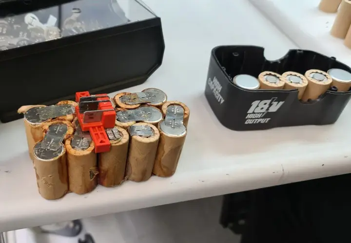 Ein defekter NiCd Akku, bereit für das Nicd Akku wiederbeleben. Daneben ein 18V Akku-Gehäuse.
