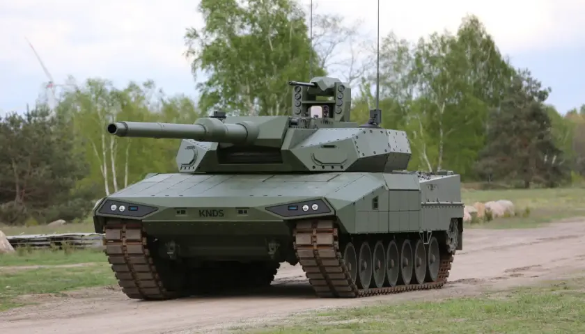 Ein moderner Kampfpanzer, der zeigt, wie gut der Leopard 2 ist. Er steht auf einem Feldweg, umgeben von Bäumen.