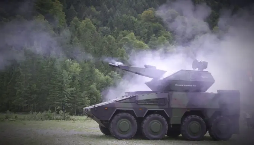 Ein moderner Radpanzer, der Nachfolger des Geparden, feuert in einer nebligen Waldkulisse.