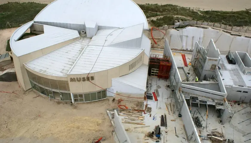 Das Utah Beach Museum im Bau, mit einer Kuppel und modernen Architektur, liegt nahe der Küste.