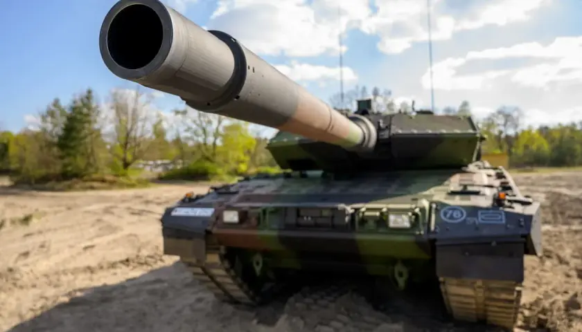 Ein moderner Kampfpanzer, wie er auch in Griechenland im Einsatz ist, steht auf sandigem Untergrund.