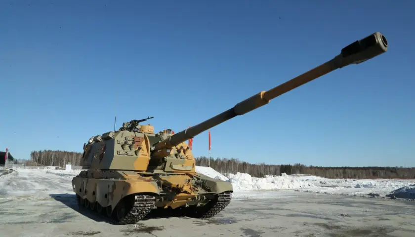 Eine russische Panzerhaubitze mit langer Kanone steht auf einem verschneiten Feld unter blauem Himmel.