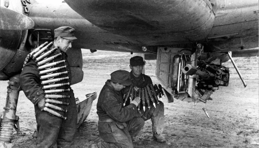 Soldaten laden Munition für ein Flugzeug. Ein Mann trägt Patronengurte, die mk 103 sind bereit.