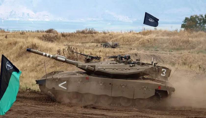 Ein Merkava Panzer fährt durch staubiges Gelände, begleitet von zwei Fahnen.