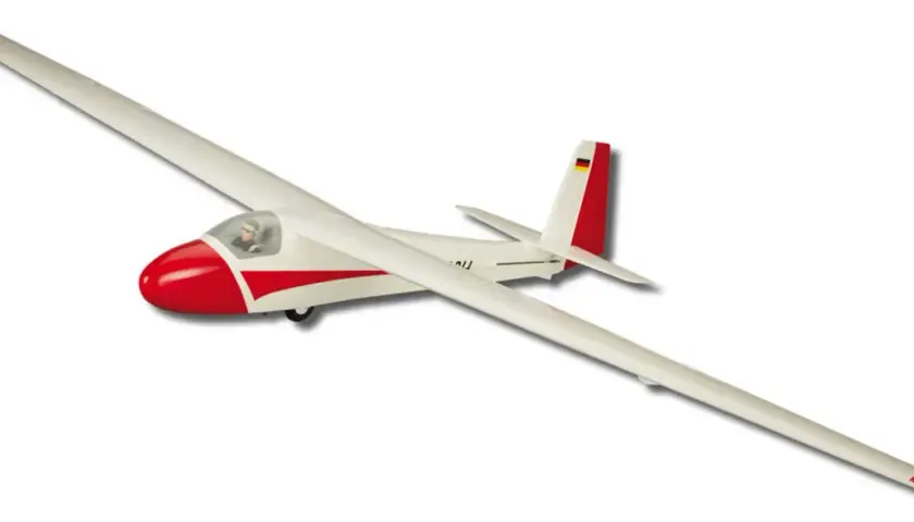 Ein weißes Modellflugzeug, ein parkzone ka-8, mit roter Nase und roten Streifen, fliegt vor weißem Hintergrund.