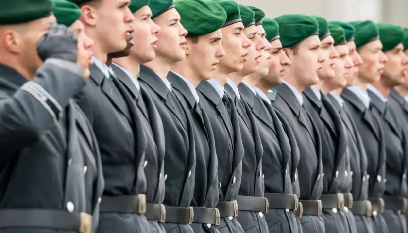 Soldaten der Bundeswehr in grünen Baretts und grauen Uniformen stehen stramm. Sie repräsentieren den niedrigsten Rang, bereit für ihren Dienst.
