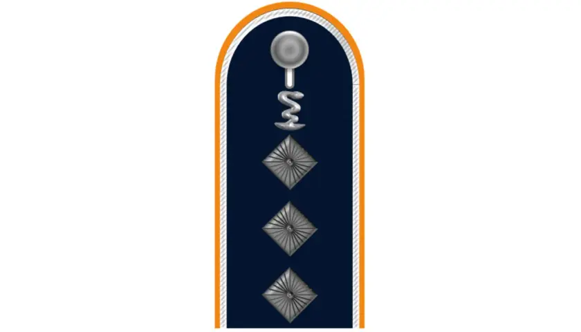 Dunkelblaues Kragenabzeichen mit silbernem Stab und Schlange, drei Rauten. Ein Feldwebel der Bundeswehr trägt dieses Abzeichen.