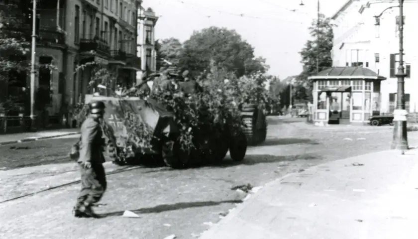 Soldat geht an getarnten Panzern vorbei in Arnheim 1944.