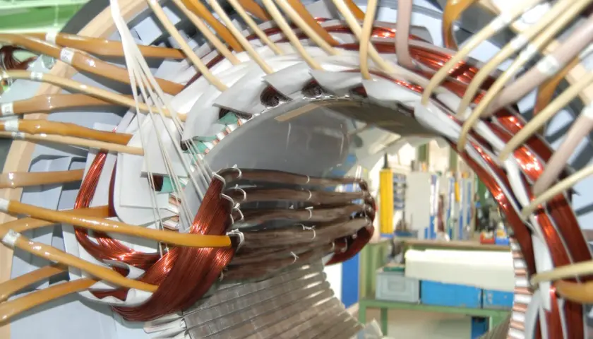 Detailaufnahme vom Wickeln eines Elektromotors mit Kupferdraht und Isoliermaterial.
