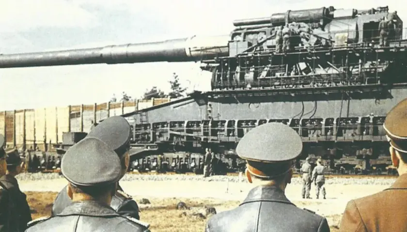 Militärs betrachten die gewaltige eiserner gustav kanone auf einem Eisenbahnwaggon.