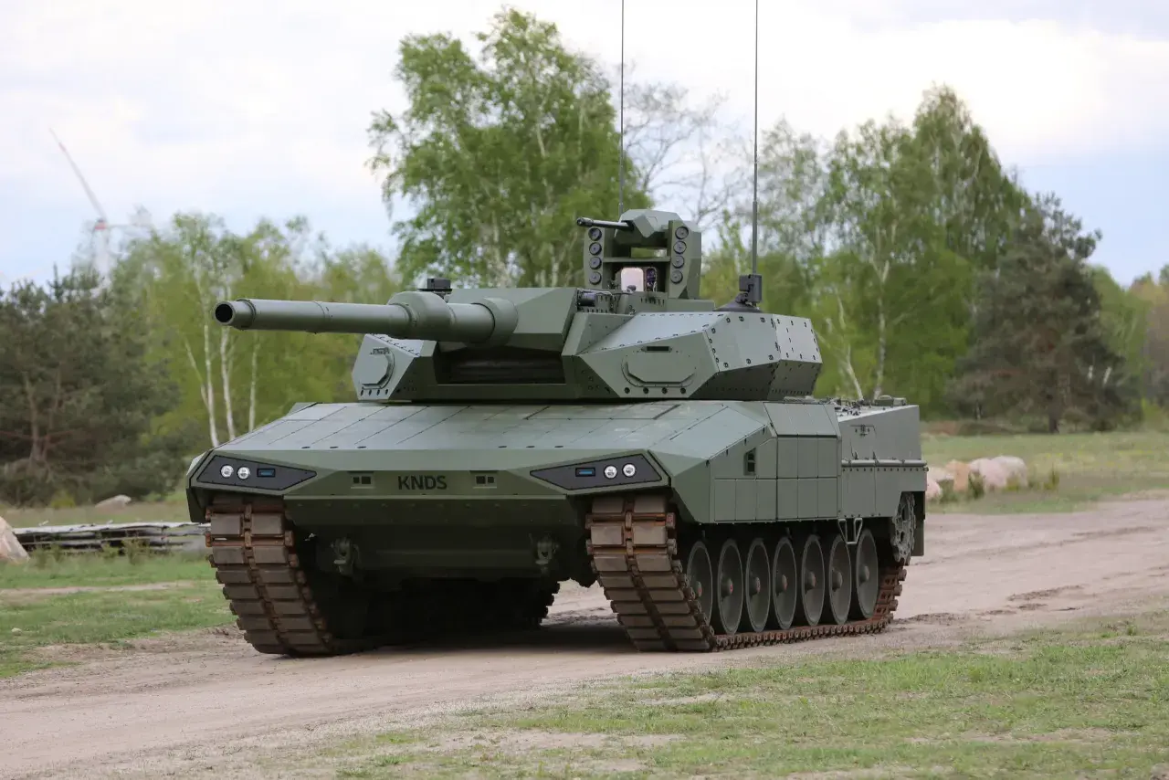 Ein moderner Kampfpanzer, der zeigt, wie gut der Leopard 2 ist. Er steht auf einem Feldweg, umgeben von Bäumen.