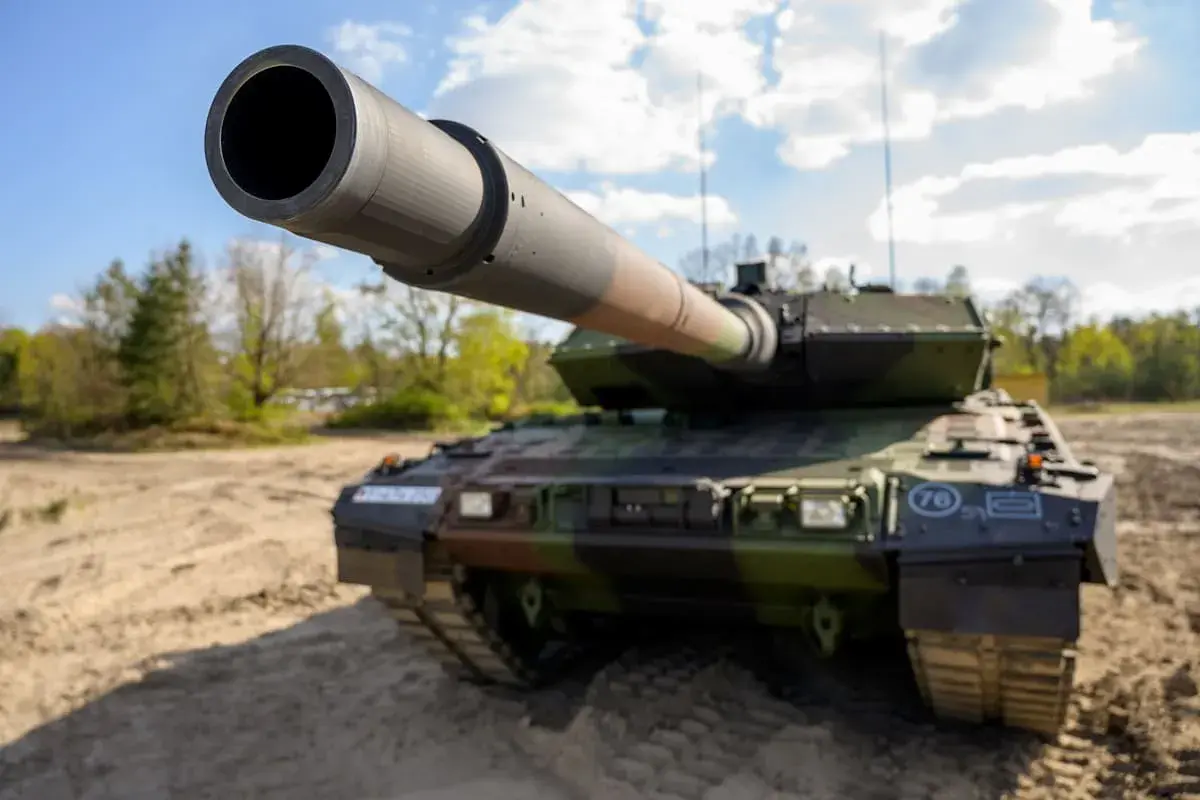 Ein moderner Kampfpanzer, wie er auch in Griechenland im Einsatz ist, steht auf sandigem Untergrund.