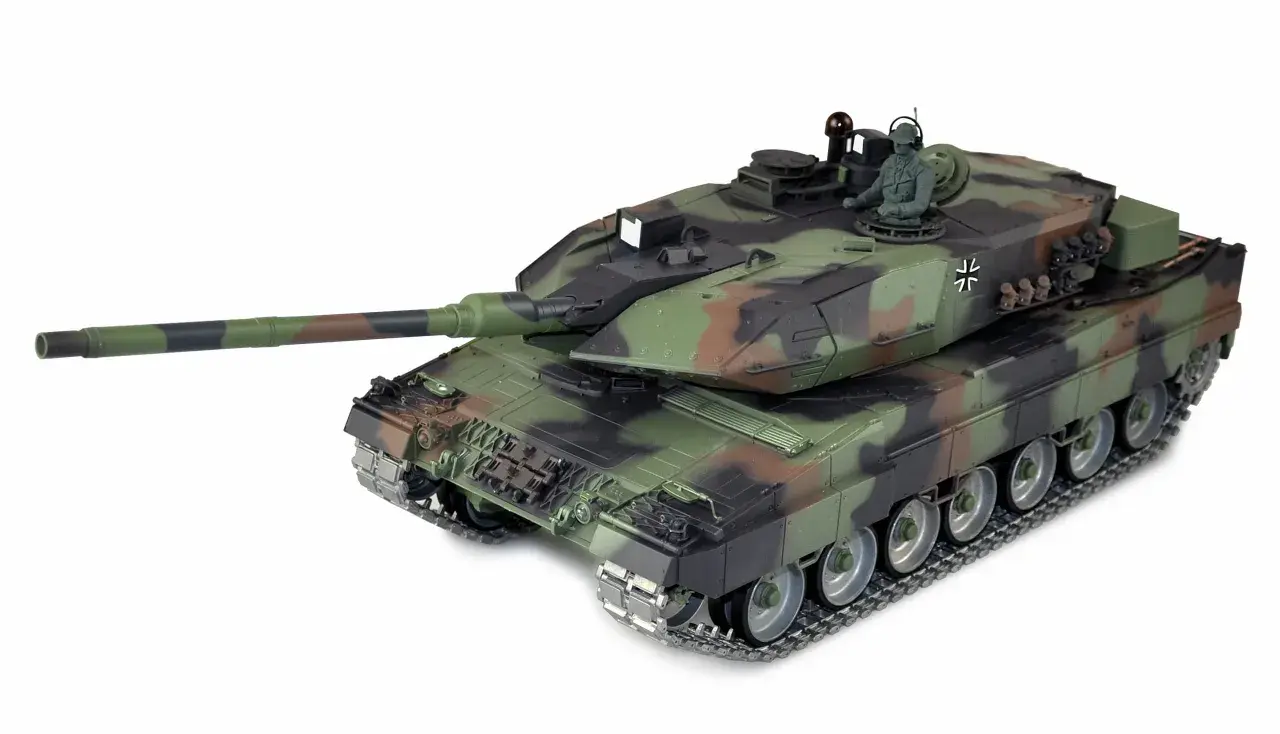 Ein detailgetreues Modell des Leopard 2A6M Panzers in Tarnfarben, mit einem sitzenden Soldaten in der Luke.