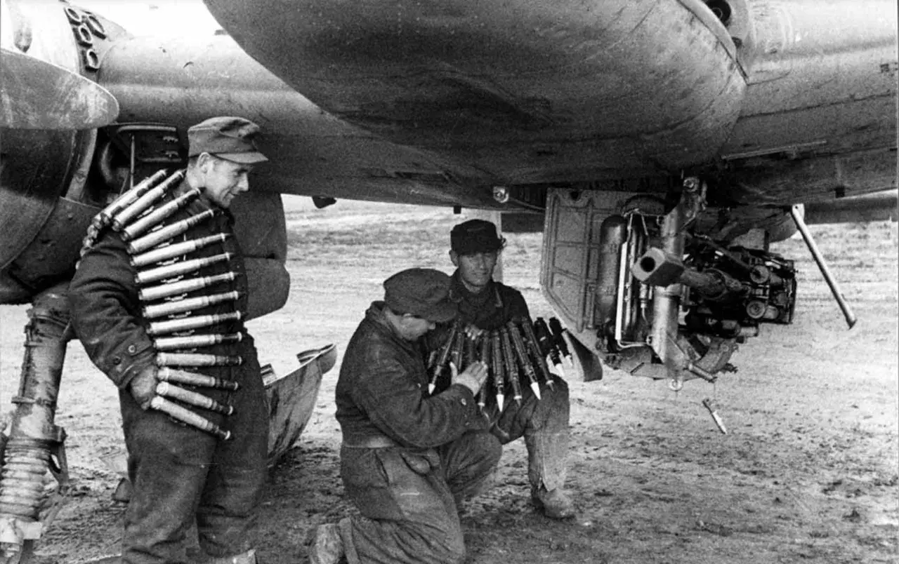 Soldaten laden Munition für ein Flugzeug. Ein Mann trägt Patronengurte, die mk 103 sind bereit.