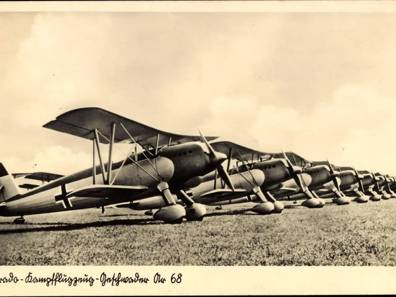 Reihe von Arado-Doppeldeckerflugzeugen auf einem Feld.