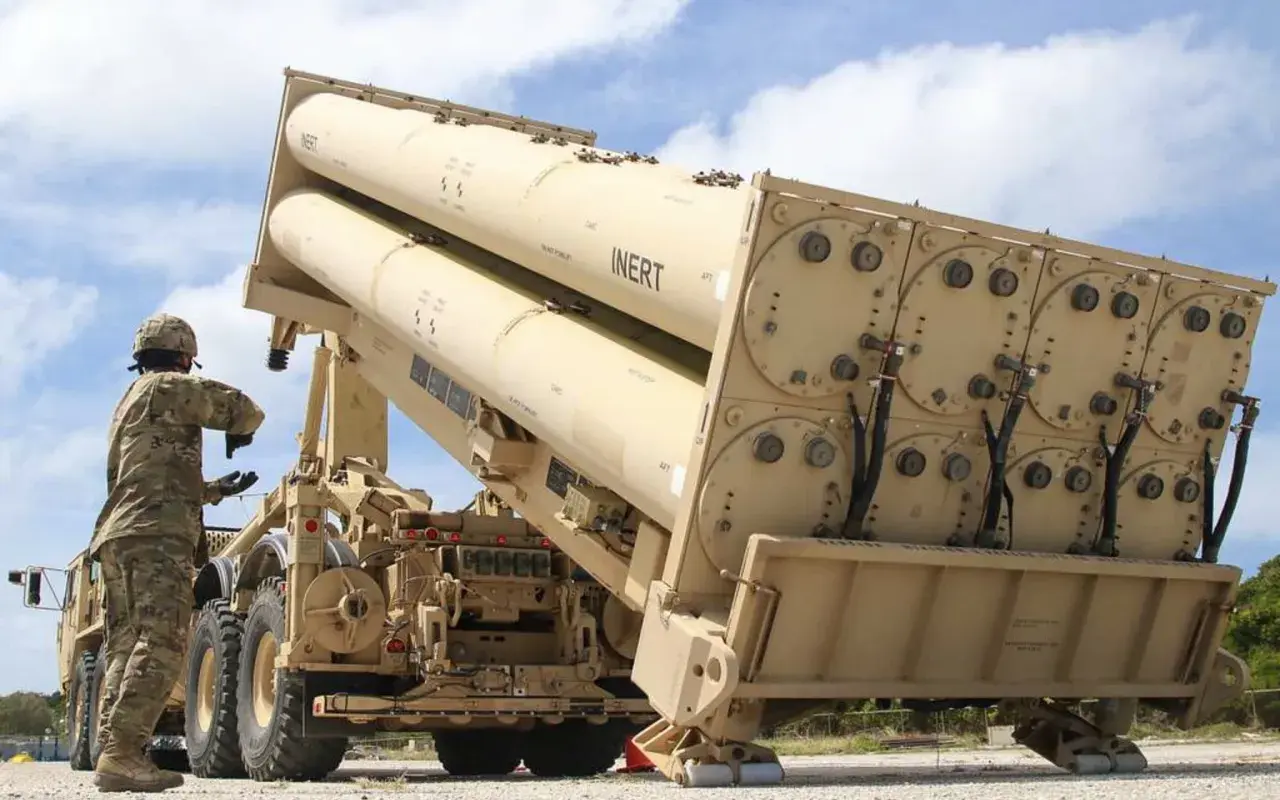 Soldat lädt Raketen für das THAAD-System. Große, beige Raketen sind auf einem LKW montiert, bereit für den Einsatz.