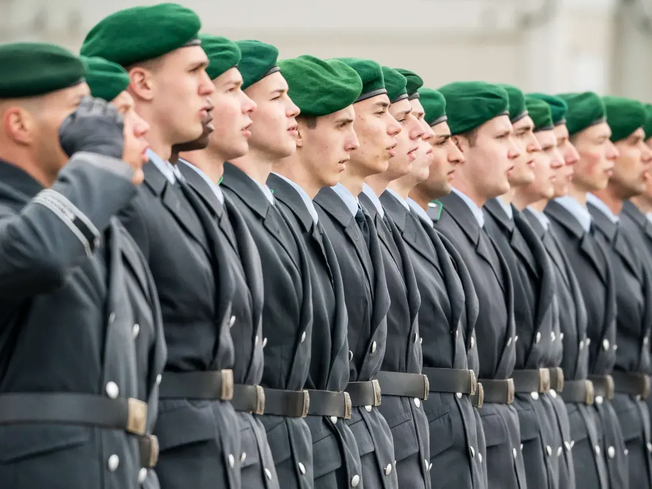 Soldaten der Bundeswehr in grünen Baretts und grauen Uniformen stehen stramm. Sie repräsentieren den niedrigsten Rang, bereit für ihren Dienst.