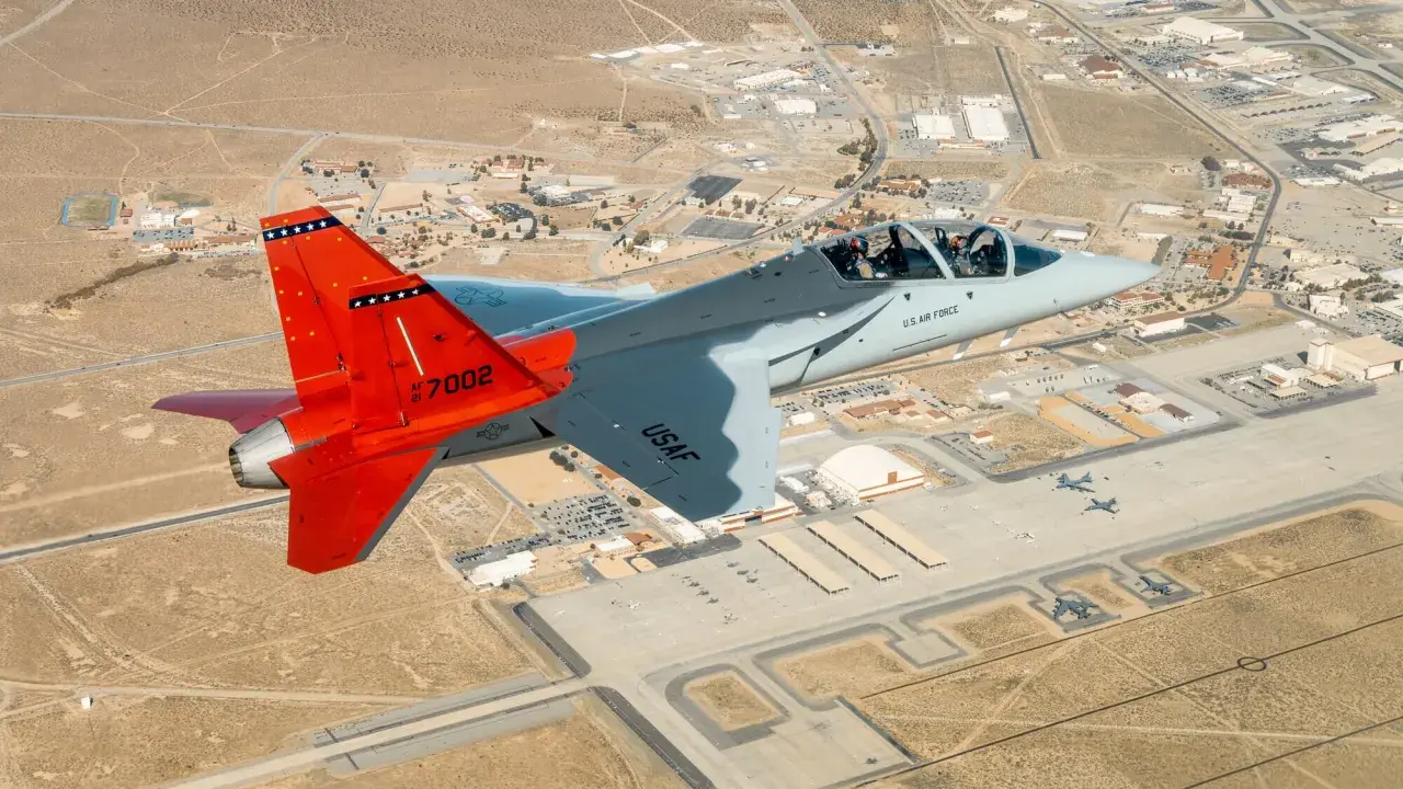 Ein T-7A Red Hawk fliegt über eine Militärbasis.