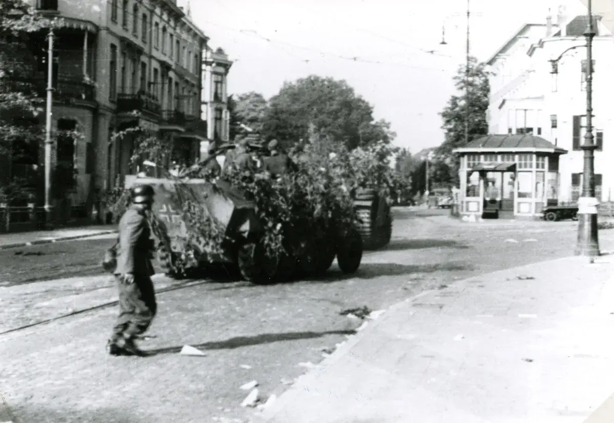 Soldat geht an getarnten Panzern vorbei in Arnheim 1944.