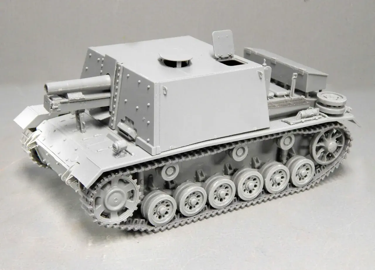 Graues Modell eines Geschützpanzers, das an die sig 33 erinnert, mit detaillierten Ketten und einer großen Kanone.