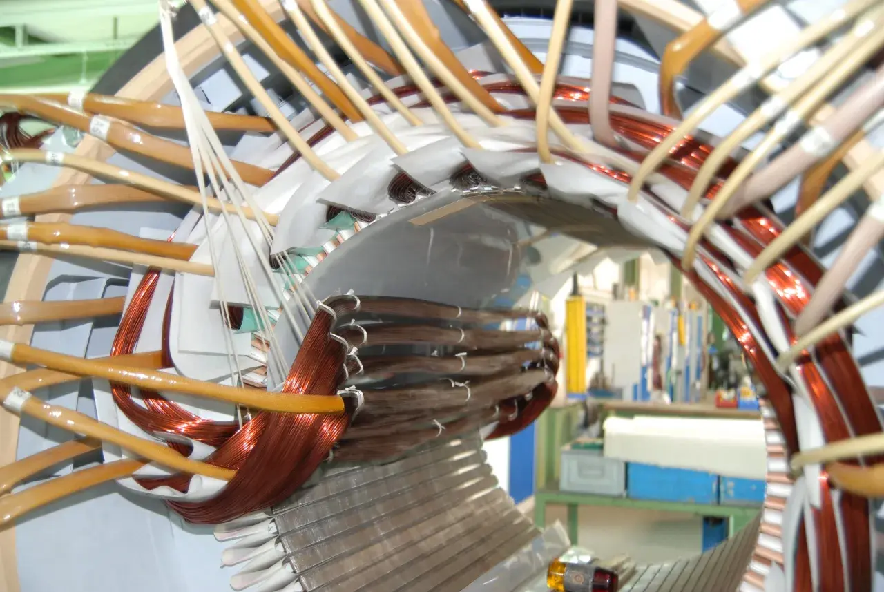 Detailaufnahme vom Wickeln eines Elektromotors mit Kupferdraht und Isoliermaterial.