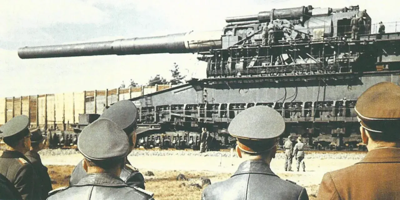 Militärs betrachten die gewaltige eiserner gustav kanone auf einem Eisenbahnwaggon.