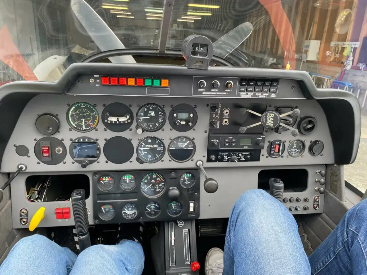 Cockpit einer Robin DR 400 mit vielen Instrumenten und Anzeigen. Die Sicht geht durch die Windschutzscheibe nach drau&szlig;en.