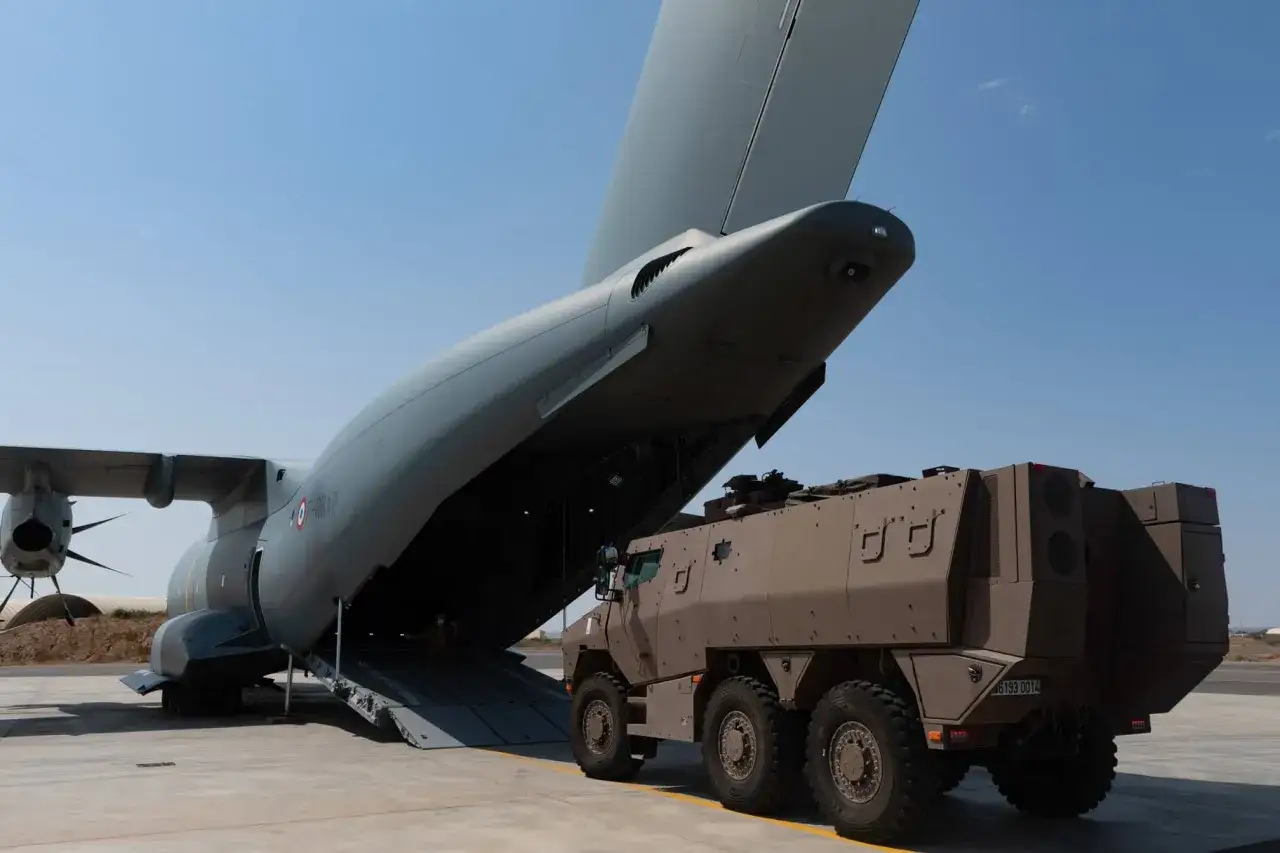 Ein gepanzertes Fahrzeug wird in ein großes Transportflugzeug geladen.