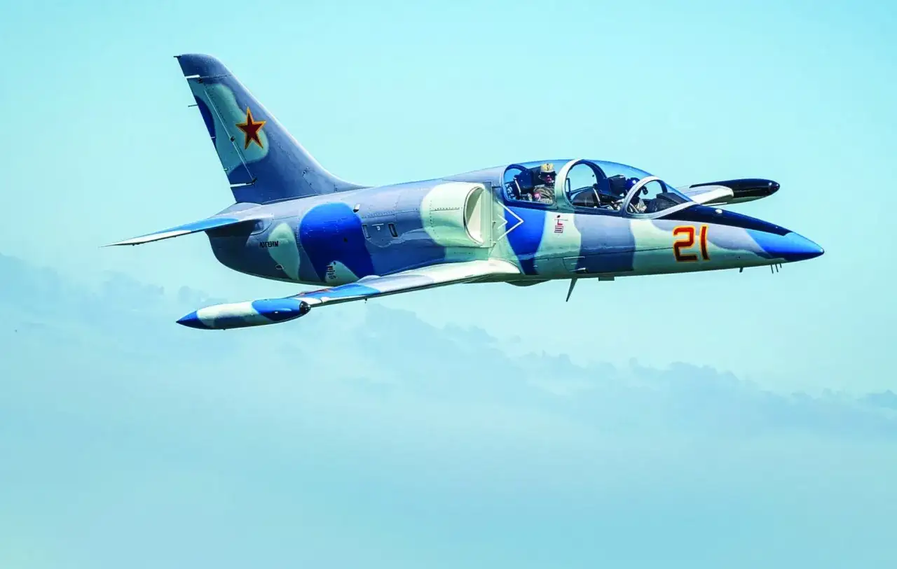 Ein blau-grau getarntes Flugzeug mit der Nummer 21 und einem roten Stern auf dem Seitenleitwerk, bereit zur albatros landung.