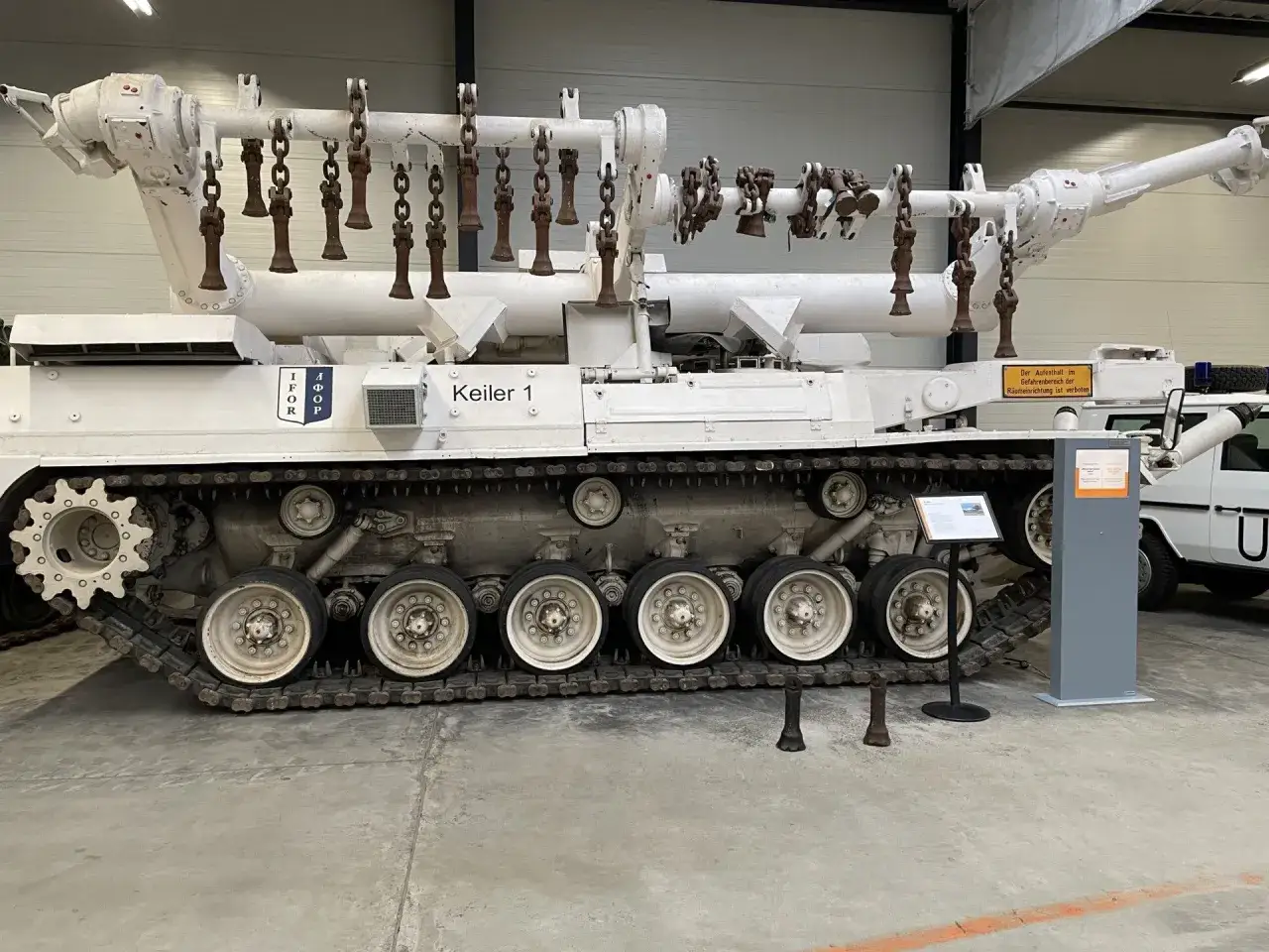Ein weißer museum panzer mit Ketten und Rädern, der
