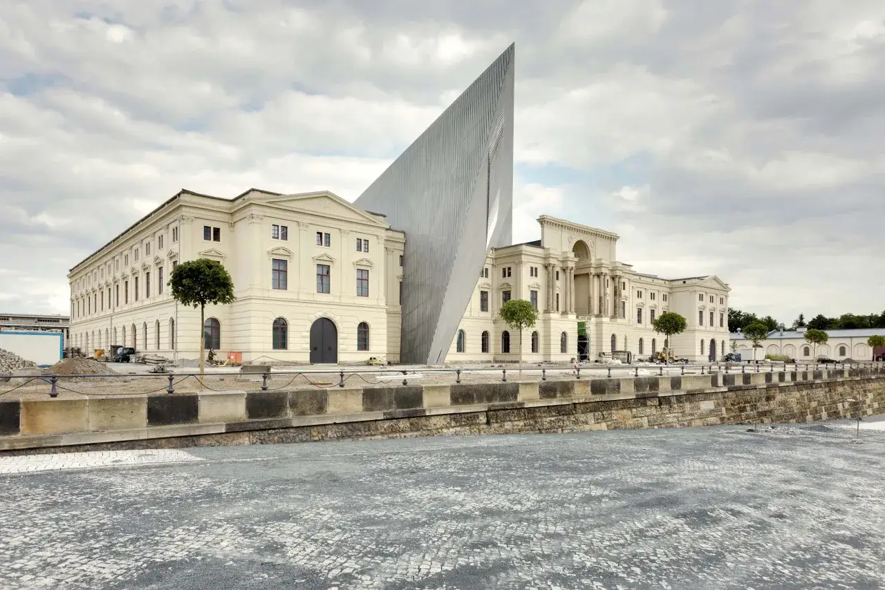 Das Milit&auml;rmuseum Dresden, ein beeindruckendes Geb&auml;ude mit moderner Spitze, steht neben einem historischen Bauwerk.