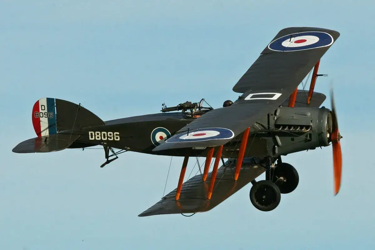 Ein Sopwith Pup Doppeldecker im Flug, mit britischen Markierungen und einer Maschinengewehr-Attrappe.