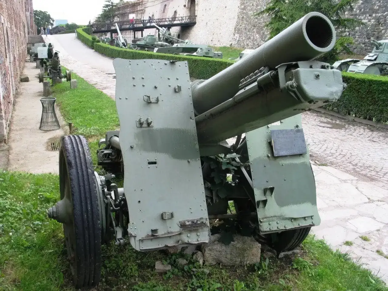 Großkalibrige Haubitze, möglicherweise eine sig 33, steht auf einem Museumsgelände neben anderen historischen Militärfahrzeugen.