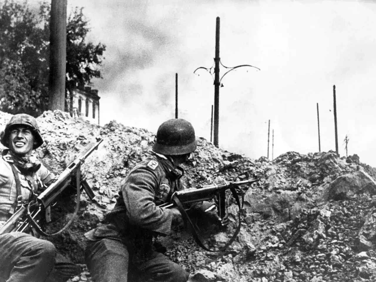 Soldaten im Kampf, ein harter Winter in Stalingrad. Rauch und Trümmer prägen die Szene, während sie sich hinter Schutt verschanzen.