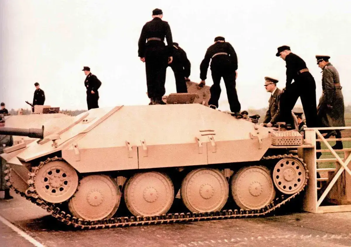Männer in Uniformen besteigen einen Opel Hetzer.