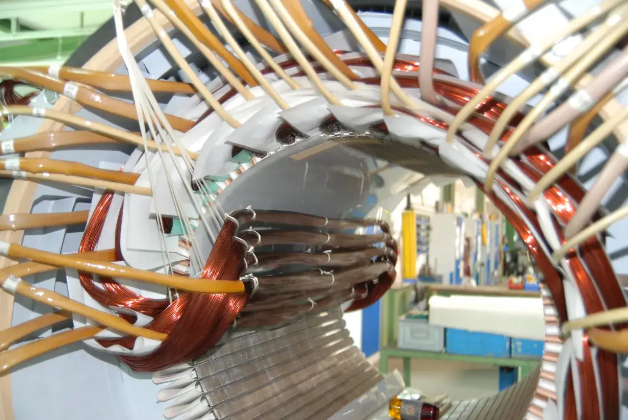 Detailaufnahme vom Wickeln eines Elektromotors mit Kupferdraht und Isoliermaterial.